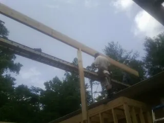 Carpenter setting a ridge beam over a new addition frame — Ice Dam Removal by Roofing Brothers in Rehoboth