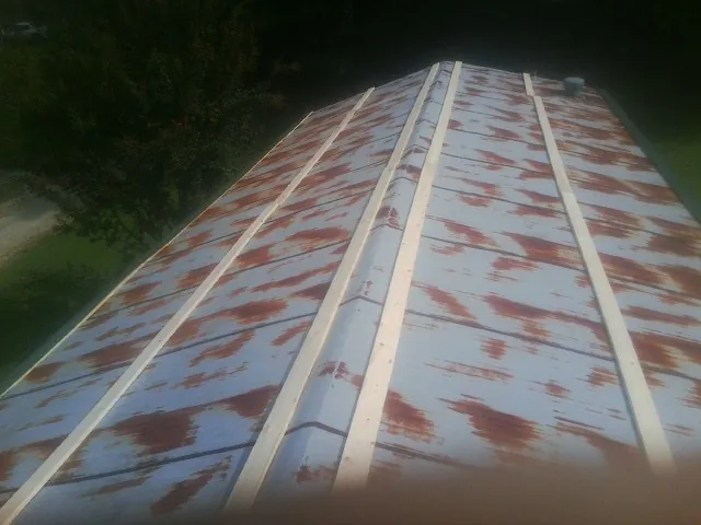 Rusted metal roof panels with new wood purlins before replacement — Storm Damage Roof Repair in Rehoboth by Roofing Brothers