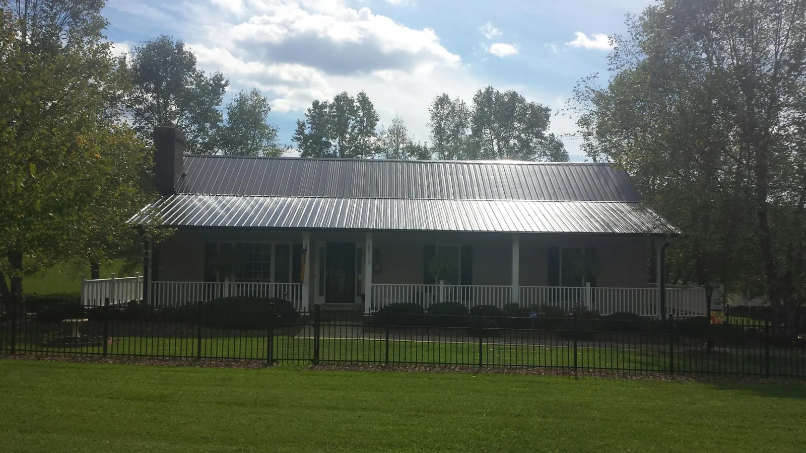 Gray metal roof on a brick ranch with a full width front porch — Gutter Guard Installation work by our crew in Rehoboth
